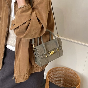 Detail of grey suede messenger bag with gold heart buckle and crossbody strap detail