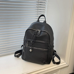 Detail of black lychee grain leather backpack with silver hardware and front pocket