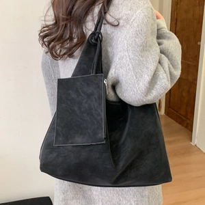 Sac cabas noir mat avec pochette suspendue porté par un mannequin au quotidien
