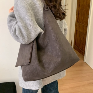 Détail macro d'un grand sac cabas rétro gris montrant le matériau texturé et la forme hobo