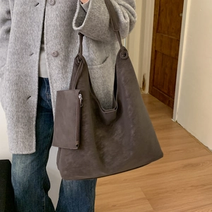 Détail du sac hobo en daim marron foncé avec mini pochette assortie et fini mat