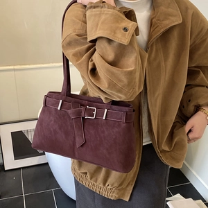 Detail of vintage burgundy tote bag with silver buckle and matte leather texture