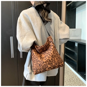 Close-up of a large leopard print hobo bag showing texture and slouchy drape on a model
