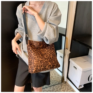 Adjustable crossbody leopard print bucket bag styled on model for daily commute use