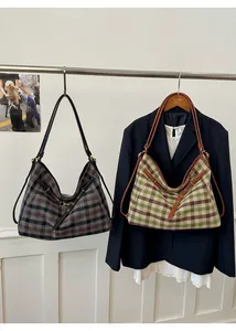 Detail view of vintage plaid canvas tote bags with leather straps and metal buckles