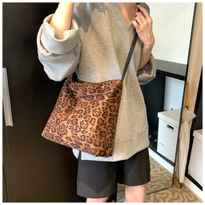 Close-up of leopard print canvas tote bag with adjustable brown shoulder strap
