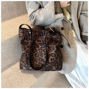 Detail of leopard print bucket bag with adjustable black strap and silver hardware