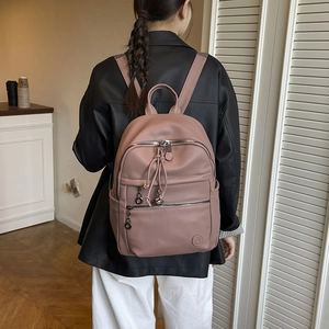 Pink lychee grain leather backpack with multiple zip pockets and stylish fringe detail
