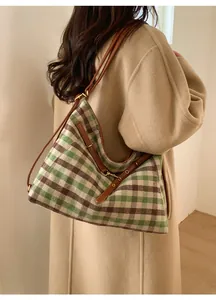 Detail of retro plaid tote bag on shoulder, green and brown weave with leather strap
