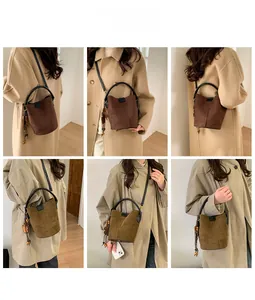 Detail of vintage bucket bag featuring wooden bead charms and adjustable crossbody strap