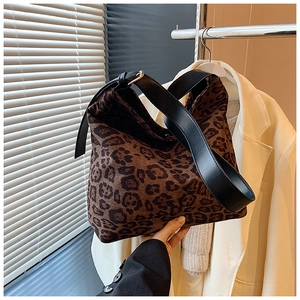 Detail of leopard print bucket bag featuring premium black leather shoulder strap