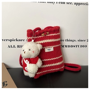 Detail of red and white striped knit bucket bag with wooden button and bear charm