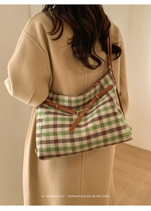 Detail der Retro-Karo-Tasche mit Tweed-Struktur und braunen Lederriemen beim Tragen