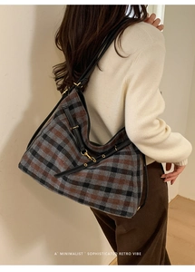 Close-up of retro plaid hobo bag with leather strap worn by model in warm lighting