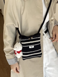 Chic knit crossbody bucket bag with black and white stripes and a cute bear charm