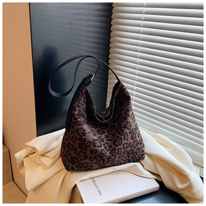 Detailed close-up of leopard print canvas hobo bag with adjustable leather shoulder strap