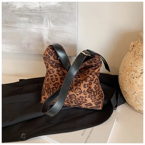Detail of leopard print shoulder bag with black strap on a designer blazer background