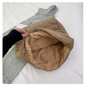 Detailed view of the spacious inner compartment and pocket of the brown quilted tote bag