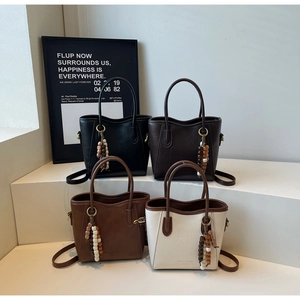 Détails de quatre sacs seaux en cuir rétro en noir, marron et beige avec charms en perles de bois
