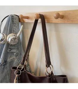 Détail des anses en cuir de cabas avec anneaux métalliques dorés pour un look quotidien