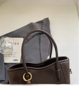 Détails du sac seau en similicuir marron avec anneaux dorés et poignée solide robuste