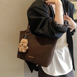 Brown vintage large capacity tote bag with matte texture and bear charm accessory
