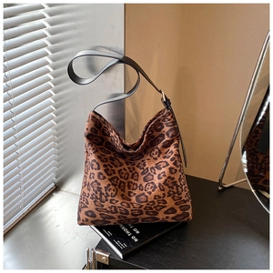 Close-up of leopard print shoulder bag featuring soft canvas texture and gold buckle