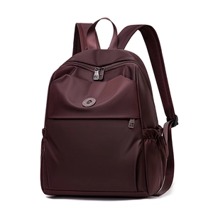 Detail view of the deep wine red oxford fabric backpack with side pockets and zippers