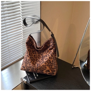 Detail of adjustable black leather strap and golden metal buckle on leopard print bag
