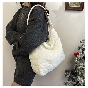 Detail of white quilted puffer tote bag featuring soft padded texture and large capacity