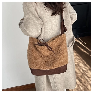 Brown fuzzy faux fur shoulder bag with drawstring detail and embroidery shown on model
