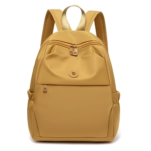 Detailed front view of mustard yellow nylon backpack featuring MSSJ logo and front pocket