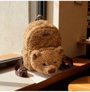 Détail d'un sac à dos ours en peluche marron doux avec tête 3D et fermeture éclair