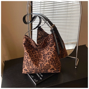 Detail of leopard print tote bag with black adjustable strap and golden hardware