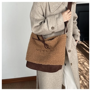 Detail view of winter plush crossbody bucket bag with CREME embroidery and fleece texture