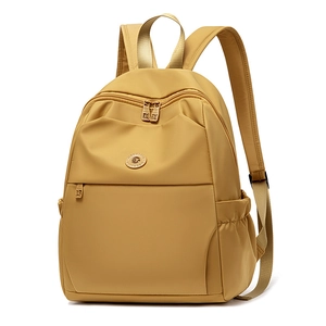 Detail of water-resistant mustard yellow nylon backpack featuring durable metal zippers