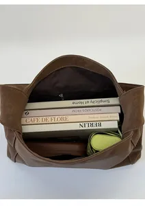 Spacious brown faux suede tote interior shown with books and a folding umbrella