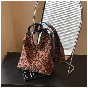 Close-up of leopard print tote bag with black leather strap on a stylish surface