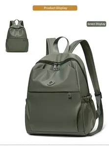 Macro detail of dark green oxford backpack showing zipper pockets and high-quality texture