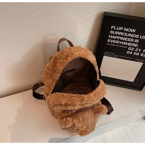 Détail de la doublure rayée et de la poche zippée à l'intérieur du sac à dos en peluche