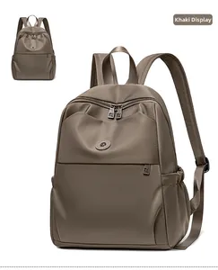 Detailed view of khaki waterproof nylon backpack with front zipper pocket and side slots