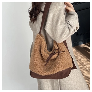 Brown faux fur hobo bag with tie detail worn over a grey wool coat for autumn style