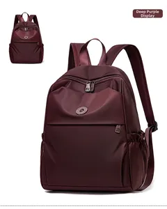 Detail view of deep purple nylon backpack with main zipper and front flap pocket
