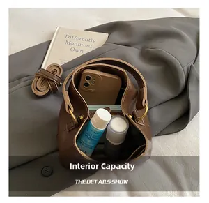 Capacité interne du sac seau marron vintage avec objets quotidiens et bandoulière
