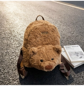 Outdoor shot of plush bear backpack featuring a 3D bear head pocket and leather handle