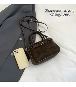 Dettaglio della borsa in pelle scamosciata marrone scuro con scala dimensionale