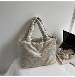 Detailed texture of satin fabric with gold Chinese architecture patterns on a grey tote bag