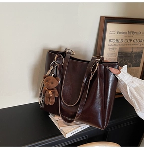 Détail du sac cabas vintage marron foncé avec un joli pendentif en peluche d'ours
