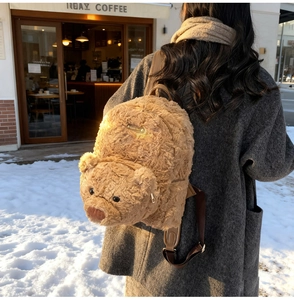 Gros plan du sac à dos en peluche ours brun montrant la texture et la plaque dorée