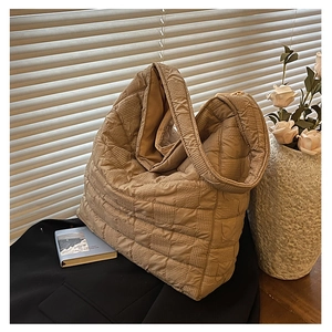 Detailed view of khaki quilted texture and soft padded fabric on the oversized tote bag